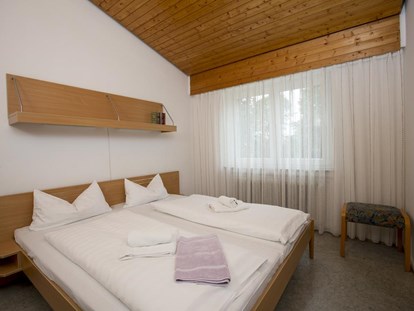 Familienhotel - Hallenbad - Allgäu - Doppelbett im Bungalow - Ferienclub Maierhöfen
