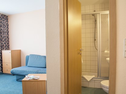 Familienhotel - Wurzbach - Familien-Studio - Wohnbereich mit Schlafcouch für Kinder und Dusche / WC - Werrapark Resort Hotel Heubacher Höhe