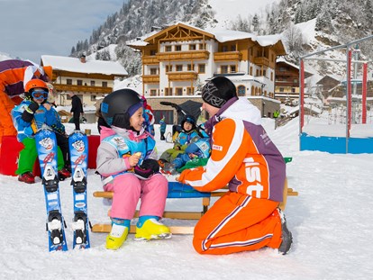 Familienhotel - Babybetreuung - Österreich - Im Skikindergarten sind unserer Betreuerinnen auch immer dabei und helfen mit - Familienhotel Oberkarteis