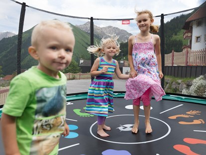 Familienhotel - Garten - Tirol - Kinder beim Trampolin hüpfen - Familotel Kaiserhof****