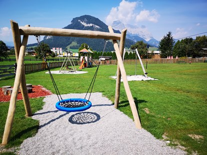 Familienhotel - Garten - Tirol - Freie Benützung der unmittelbar angrenzenden Spielwiese mit Nestschaukel, Seilrutsche, Spielturm und Trampolin - Hotel babymio