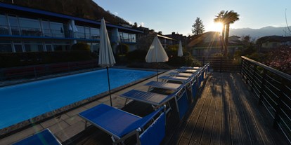 Familienhotel - Suiten mit extra Kinderzimmer - Schweiz - Poolterrasse am Abend - Top Familienhotel La Campagnola