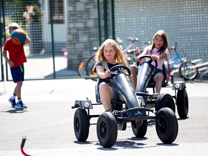 Familienhotel - Kinderbetreuung - Österreich - Go Karts und Fahrräder stehen für die Kinder bereit - Hotel Felsenhof