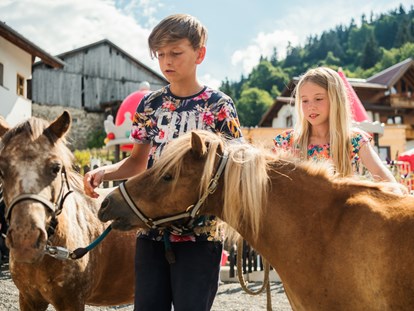 Familienhotel - Garten - Tirol - Im Sommer gibt es vormittags immer Pony reiten - Kinderhotel Laderhof
