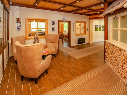 Familienhotel - Egg am Faaker See - Rezeptionsbereich mit freundlichen, ugemütlichen Ausstattungen aus Holz - Familienhotel Schneekönig