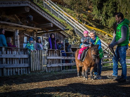 Familienhotel - Wellnessbereich - Tirol - Pony Reiten am Streichelzoo direkt im Hotelgarten - Alpin Family Resort Seetal