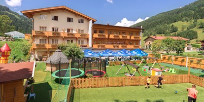 Familienhotel - Spielplatz - Großarl - Außenansicht mit spielenden Kindern - Familienhotel Botenwirt ***S