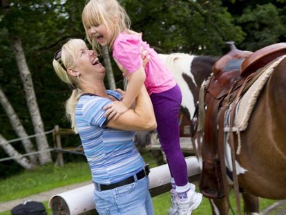 Familienhotel - Spielplatz - Bayern - Kinder reiten auf Pferde - Ferienclub Maierhöfen