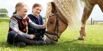 Familienhotel - Kinderwagenverleih - Nordseeküste - Kinder bei den Pferden - Frieslandstern - Ferienhof und Hotel