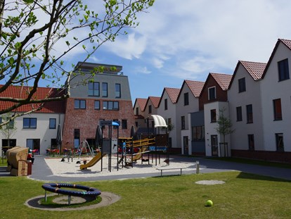 Familienhotel - Teenager-Programm - Ostfriesland - Innenhof mit Spielplätzen und großer Terrasse - Hotel Deichkrone - Familotel Nordsee