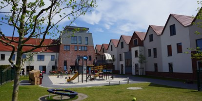 Familienhotel - Babysitterservice - Nordsee - Innenhof mit Spielplätzen und großer Terrasse - Hotel Deichkrone - Familotel Nordsee