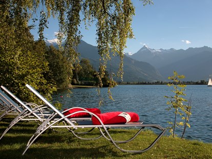 Familienhotel - Kinderbecken - Oberndorf in Tirol - Hoteleigener Badestrand am Zeller See mit Matschplatz, Liegewiese, und kostenfreien Tretbooten - Familotel amiamo