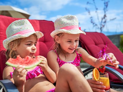 Familienhotel - Kinderbecken - Fieberbrunn - genießen am Pool mit Kindercocktails und frischem Obst - Familotel amiamo
