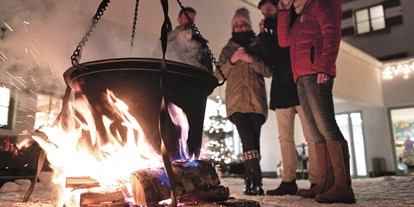 Familienhotel - Garten - Pinzgau - Begrüßung mit Glühwein und Kinderpunsch am Lagerfeuer - Familotel amiamo