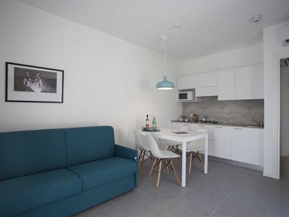 Familienhotel - Einzelzimmer mit Kinderbett - Peschiera del Garda - Wohnzimmer mit Küche - SISAN Family Resort