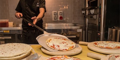 Familienhotel - Kinderbetreuung in Altersgruppen - Emilia Romagna - Köstliche Pizzen werden zubereitet - Europa Monetti LifeStyle & Family Hotel