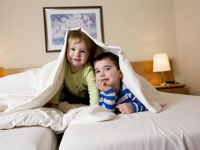 Familienhotel - Umgebungsschwerpunkt: am Land - Braunlage - Kinder im Bett - Der WOLFSHOF