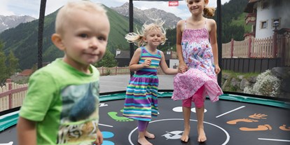 Familienhotel - Spielplatz - Fiss - Kinder beim Trampolin hüpfen - Familotel Kaiserhof****