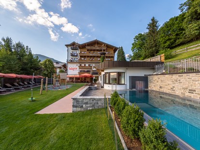 Familienhotel - Umgebungsschwerpunkt: Berg - Kitzbühel - Hotel mit Liege- und Spielbereich, Aussenpool mit Whirlbank, Sommer und Winter beheizt bis 33°C - Hotel babymio