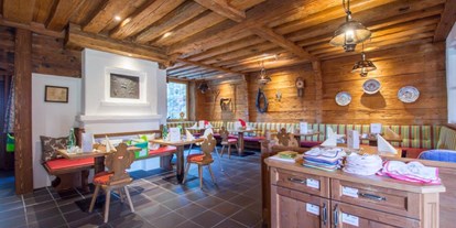 Familienhotel - Kinderbetreuung - Tiroler Unterland - Kaminstube, Lätzchen, Besteck und Teller für Kleinkinder zum nehmen - Hotel babymio
