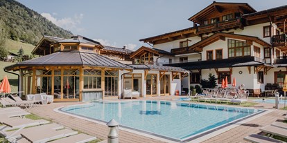 Familienhotel - Garten - Pinzgau - Pool Ansicht vom Stammhaus - Feriendorf Ponyhof