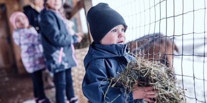 Familienhotel - Teenager-Programm - Tiere füttern im Winter - Familienresort Ellmauhof - das echte All Inclusive ****S