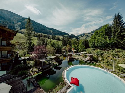 Familienhotel - Kinderbecken - Oberndorf in Tirol - Pool, Schwimmteich und Relaxinseln aus der Vogelperspektive - Gartenhotel Theresia****S - DAS "Grüne" Familienhotel 