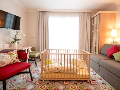 Familienhotel - Babyphone - Familienzimmer - Wohnbereich mit Gitterbett - Hotel Felsenhof