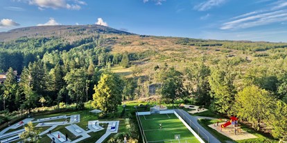 Familienhotel - Verpflegung: Halbpension - Bodensee - Außenanlage und Blick auf den Wurmberg - AHORN Harz Hotel Braunlage