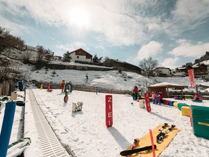 Familienhotel - Umgebungsschwerpunkt: See - Österreich - unterhalb vom Hotel lernen die Anfänger spielerisch das Ski fahren - Kinderhotel Laderhof