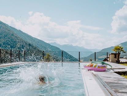 Familienhotel - Pools: Außenpool beheizt - Obereggen (Trentino-Südtirol) - Outdoor Natursteinpool - Hotel Bergschlössl