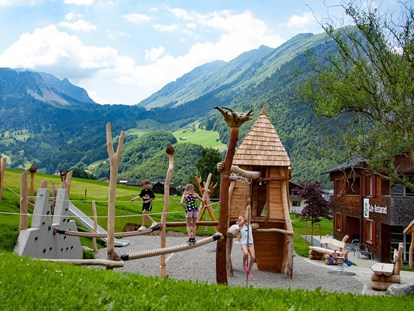 Familienhotel - Babybetreuung - Klosters - Spielplatz mit Klettermöglichkeit, Rutsche, Sandkasten, Wasserpumpe, Dreiradrange, Schaukel,.... - ****Alpen Hotel Post