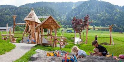 Familienhotel - Teenager-Programm - Vorarlberg - Spielplatz mit Klettermöglichkeit, Rutsche, Sandkasten, Wasserpumpe, Dreiradrange, Schaukel,.... - ****Alpen Hotel Post
