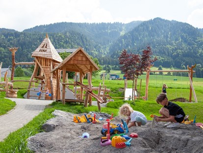 Familienhotel - Umgebungsschwerpunkt: Berg - Vorarlberg - Spielplatz mit Klettermöglichkeit, Rutsche, Sandkasten, Wasserpumpe, Dreiradrange, Schaukel,.... - ****Alpen Hotel Post