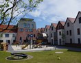 Kinderhotel: Innenhof mit Spielplätzen und großer Terrasse - Hotel Deichkrone - Familotel Nordsee