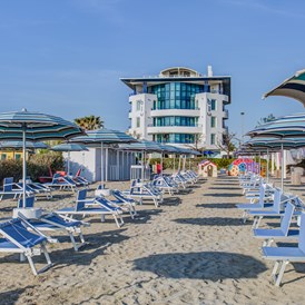 Kinderhotel: Privater Strand dem Hotel gegenueber mit Sonnenschirmen und Liegen zur Verfuegung - Blu Suite Hotel