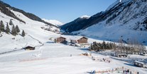 Familienhotel - Garten - Zillertal - Hausansicht mit Talabfahrt & Übungslift der Skischule - Kinder- & Gletscherhotel Hintertuxerhof