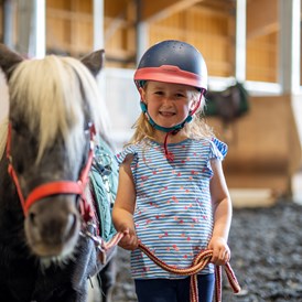 Kinderhotel: Pony- & Pferdefans kommen hier voll auf ihre Kosten - dank Reithalle bei jedem Wetter. Absolutes Highlight? Das Pony Camps in den Ferien! - Elldus Resort - Familotel Erzgebirge