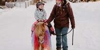 Familienhotel - Skilift - Reitpädagogik mit unseren Ponys im Winter, ab April gibt es Ponyreiten. - Habachklause Familien Bauernhof Resort