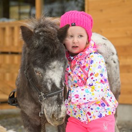 Familienhotel: Mädchen kuschelt mit dem Pony - Familienhotel Auhof