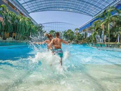 Familienhotel - Pools: Außenpool beheizt - Oberbayern - Im Sommer fahren wir "oben Ohne".
Bei gutem Wetter öffnet sich das Dach des Wellenbads und man hat das Gefühl direkt unter dem freien Himmer der Südsee zu schwimmen. - Hotel Victory Therme Erding 