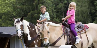Familienhotel - Hallenbad - Bayern - Kinder reiten auf Pferde - Ferienclub Maierhöfen