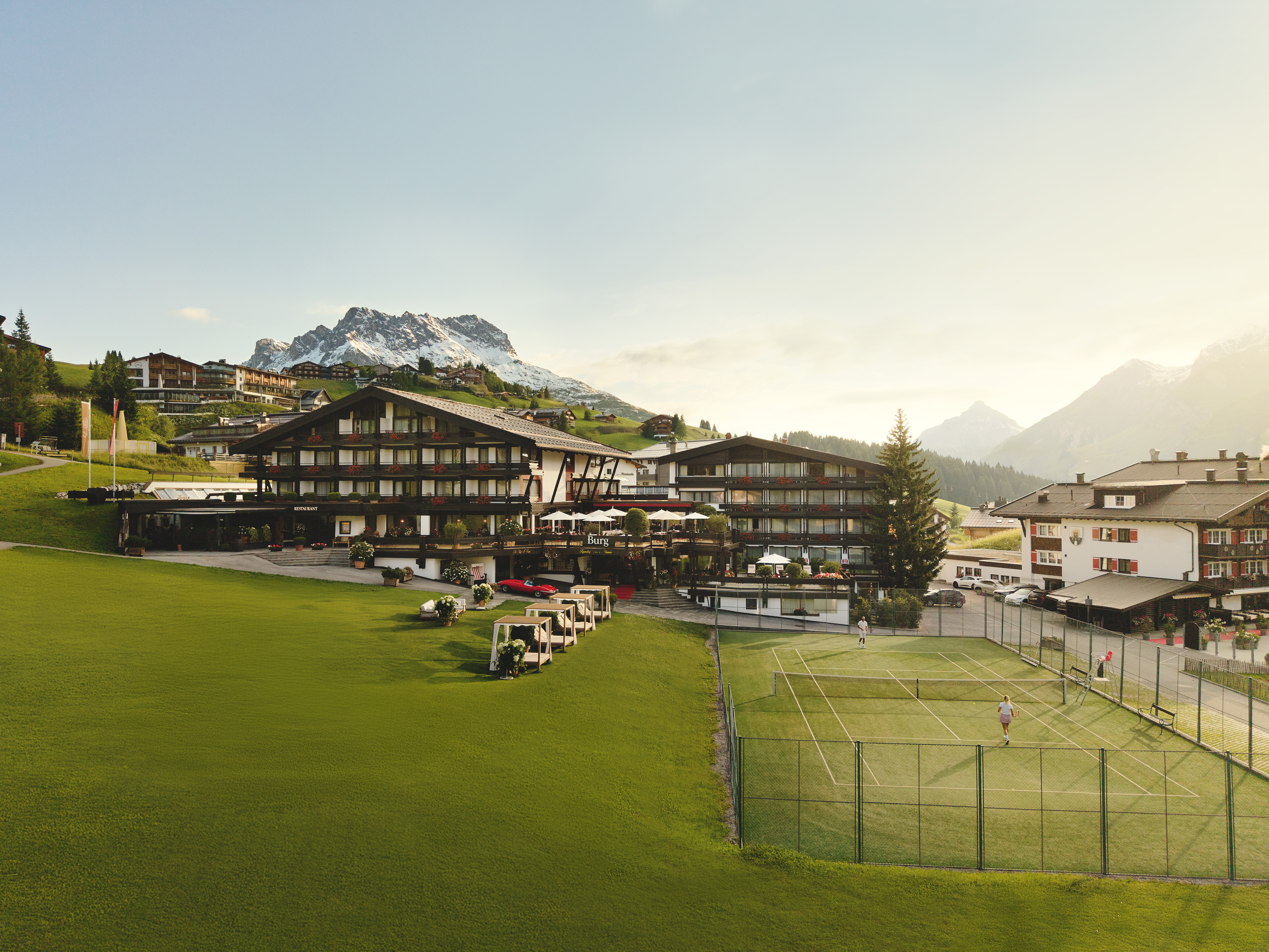 Kinderhotel - Burg Hotel Lech am Arlberg im Sommer mit hauseigenem Tennisplatz - Burg Hotel Lech am Arlberg