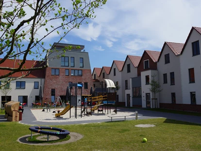 Familienhotel - Kinderbecken - Innenhof mit Spielplätzen und großer Terrasse - Hotel Deichkrone - Familotel Nordsee