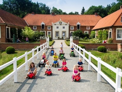 Familienhotel - Spielplatz - Niedersachsen - Kinder beim Bobby Car fahren - Gut Landegge Familotel Emsland