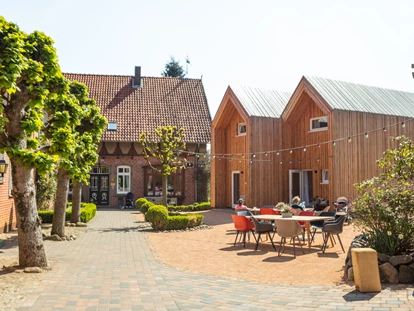 Familienhotel - Kinderbecken - Innenhof mit den Cabins und dem Bauernhaus - Familotel Landhaus Averbeck