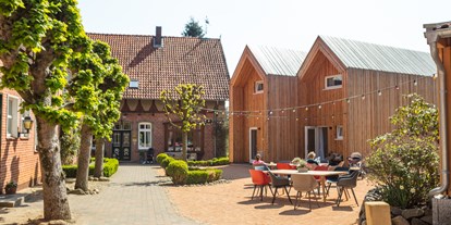 Familienhotel - Ausritte mit Pferden - Innenhof mit den Cabins und dem Bauernhaus - Familotel Landhaus Averbeck