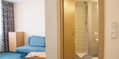Familienhotel - Oberhof (Landkreis Schmalkalden-Meiningen) - Familien-Studio - Wohnbereich mit Schlafcouch für Kinder und Dusche / WC - Werrapark Resort Hotel Heubacher Höhe