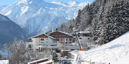 Familienhotel - Skikurs direkt beim Hotel - Hotelansicht Winter - direkt an der Piste - Familotel amiamo