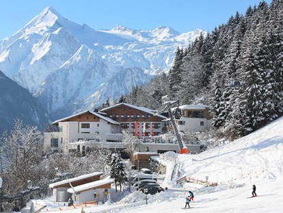 Familienhotel - Skikurs direkt beim Hotel - Hotelansicht Winter - direkt an der Piste - Familotel amiamo